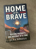 Book titled 'Home of the Brave: Raising Patriots One Holiday at a Time' by Jana Spruce on a textured surface